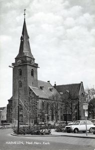 10501 Gezicht op de toren en de rechtergevel van de N.H.-kerk in de bebouwde kom van Harmelen uit het westen.N.B. De ...